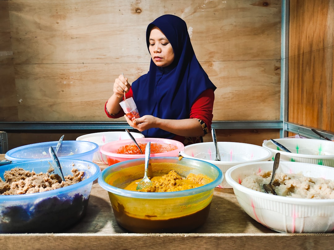 A Peranakan cuisine cook presents traditional nyonya dishes at a heritage restaurant table in Singapore