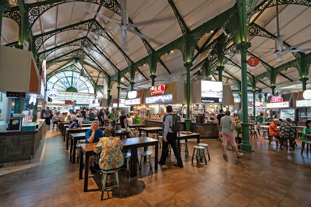 A smiling traveller enjoys a budget getaway meal at a busy Singapore hawker centre