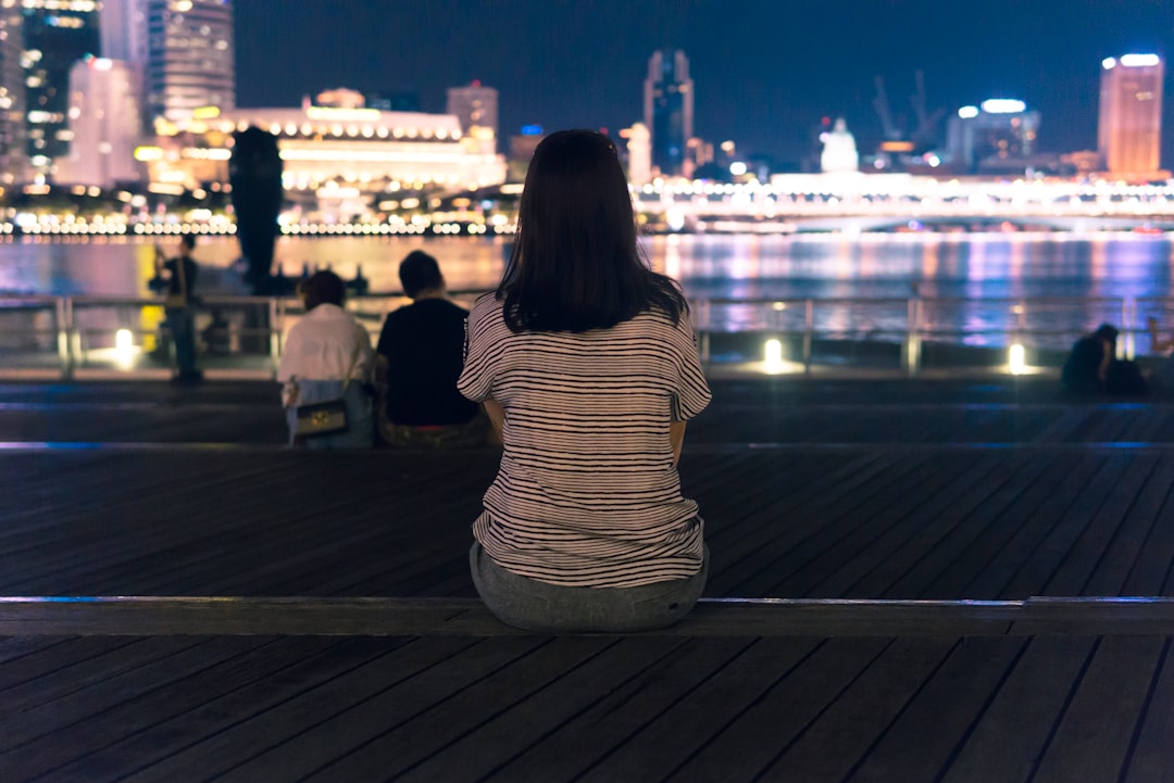 strolling the Marina Bay waterfront during June events in Singapore, surrounded by glowing light installations at night