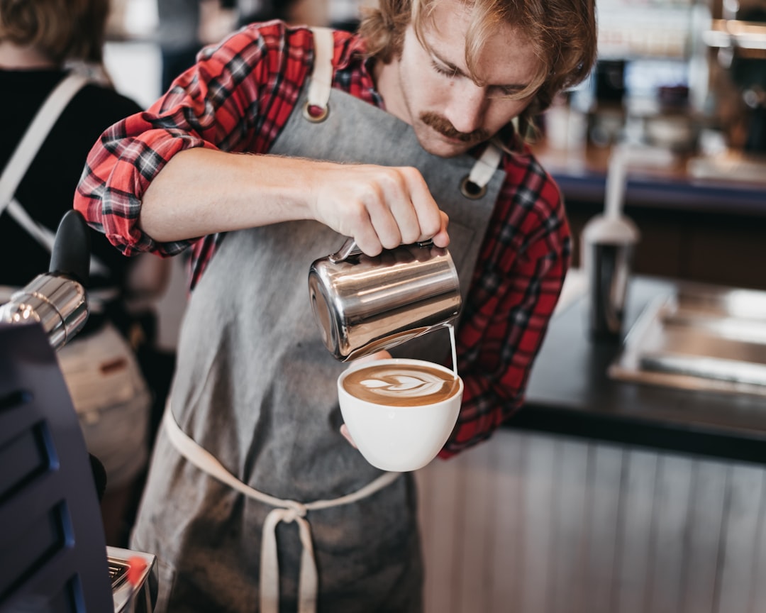 A skilled barista concentrates during a Singapore coffee championship latte art round