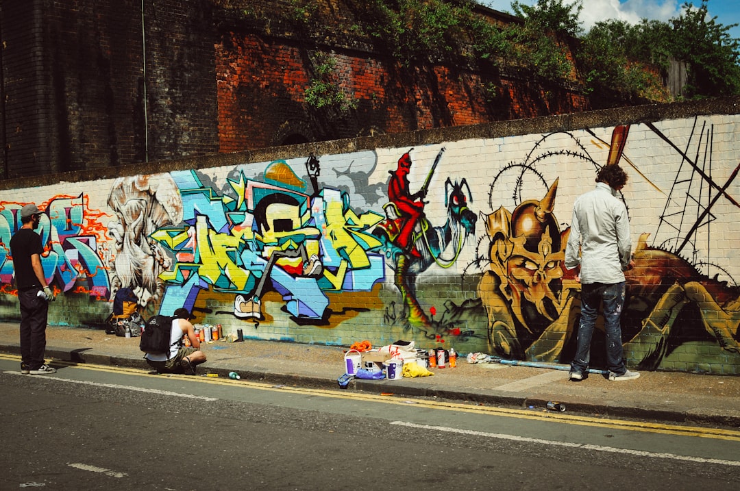 A young person painting a large street art mural on an outdoor wall during a Singapore youth programme