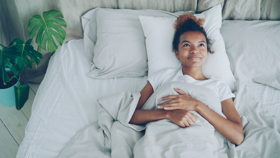 A woman lying awake in a warm Singapore bedroom, struggling with July humidity and poor sleep