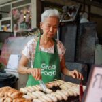 A woman enjoying a plate of food at a Singapore vegetarian hawker stall in a busy food centre