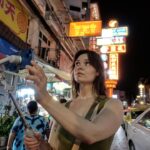 A man uses her smartphone to begin a short film practice on a busy Singapore street