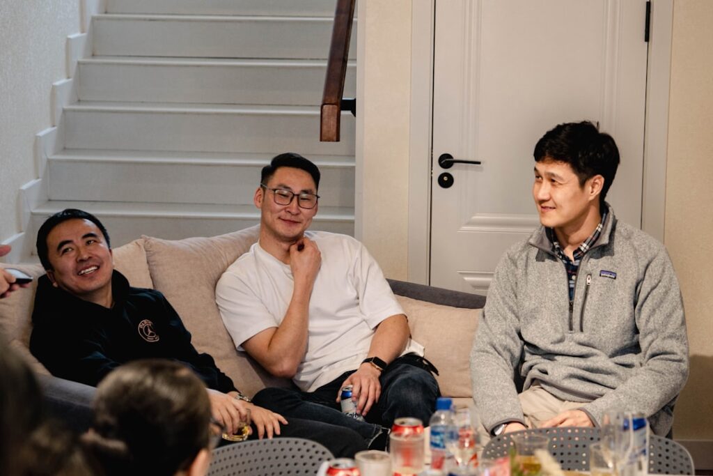 A group of Singaporean friends cheering together as they watch the Grand Prix Singapore race on a television screen at home