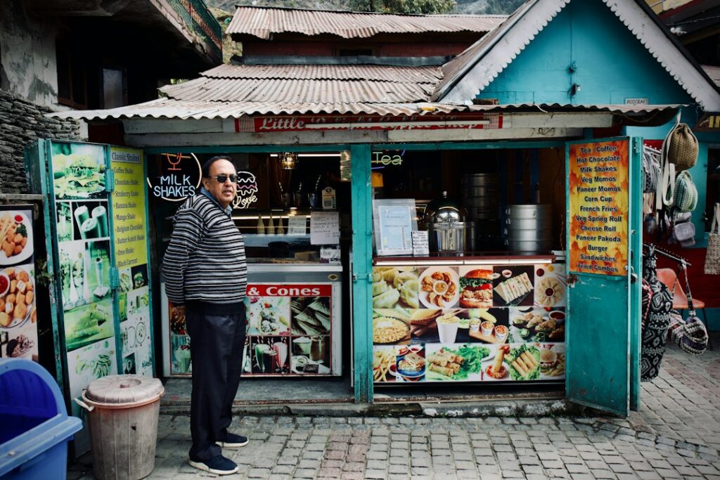 Hawker stall owner displaying hygiene grades decal at counter