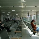 Traveler comparing year-end flights deals on a phone at Changi Airport